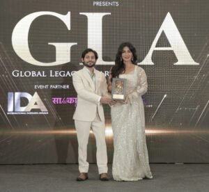 Kumar Shivam receiving the Global Excellence Award 2026 on behalf of Higher Education Centre and Trula Overseas from Bollywood actress Chitrangada Singh at an award ceremony.
