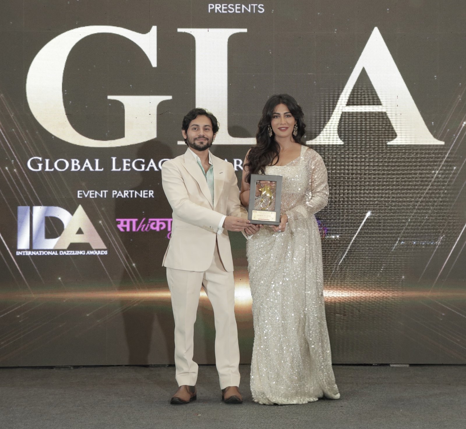 Kumar Shivam receiving the Global Excellence Award 2026 on behalf of Higher Education Centre and Trula Overseas from Bollywood actress Chitrangada Singh at an award ceremony.